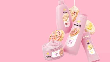 Un'immagine dei prodotti Crumbl di Dove, tra cui la torta sbriciolata alle fragole, la torta ai coriandoli e la glassa al limone su sfondo rosa.