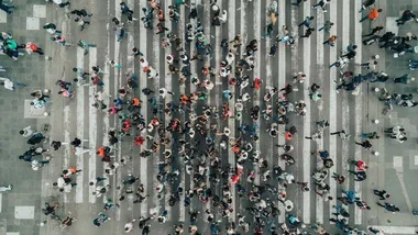 Fotografia aerea di un gran numero di persone che attraversano una strada.